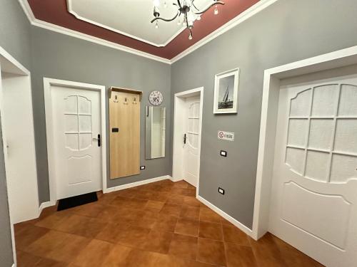 a hallway with white doors and tile floors at THE DOMI Apartments in Durrës