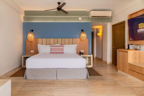 a bedroom with a large white bed and a kitchen at Camino Real Acapulco Diamante in Acapulco