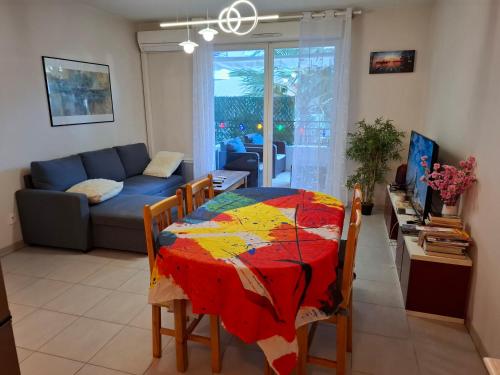 - un salon avec une table et une couette colorée dans l'établissement Appartement Beau Sejour, à Marseille