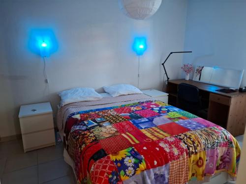 - une chambre avec un lit, un bureau et des lumières bleues dans l'établissement Appartement Beau Sejour, à Marseille