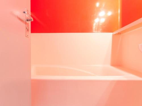 La salle de bains est pourvue d'une cabine de douche rouge et blanche. dans l'établissement Studio 4 pers. · Ski aux pieds · Balcon - FR-1-346-458, à Arc 1800