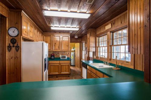 a kitchen with wooden cabinets and a white refrigerator at Drop Anchor A Dog-Friendly Home with Beach Access in Pawleys Island