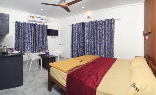 a bedroom with a large bed with blue curtains at M M Residency in Cochin
