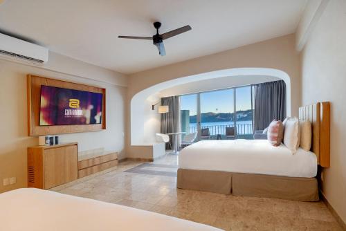 a hotel room with two beds and a large window at Camino Real Acapulco Diamante in Acapulco