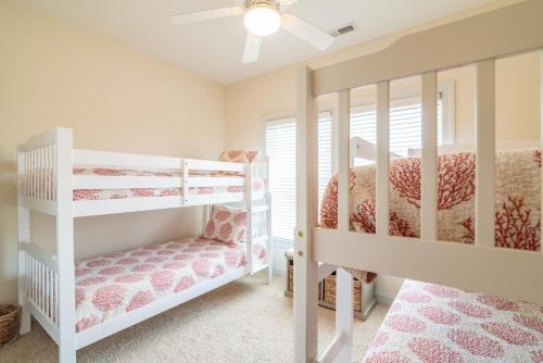 sypialnia z 2 łóżkami piętrowymi i wentylatorem sufitowym w obiekcie Luxurious Beachfront Escape with Spectacular Views w mieście Pawleys Island