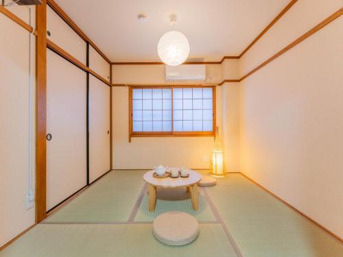 a room with a table in the middle of a room at 心斎橋梅田京都usjなど人気観光エリアへアクセス抜群4ベットルーム3階建て貸切 in Osaka