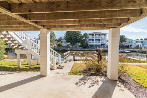 a woodenilion with stairs and a building in the background at Cozy and Tranquil Creekfront Cottage in Litchfield in Pawleys Island