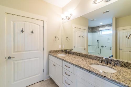 Un baño con dos lavabos y un espejo grande. en Paradise Point: Luxury Beachfront Home with Views, en Pawleys Island
