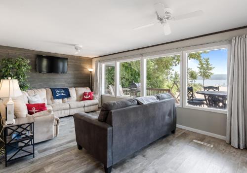 a living room with two couches and a large window at Dunes Edge- Private Silver Lake Home in Mears