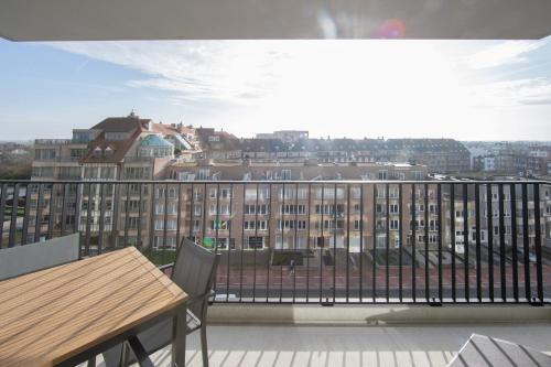 a balcony with a table and a view of a building at H&D at Sea in Blankenberge