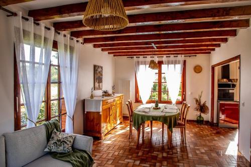 un salon avec une table, des chaises et des fenêtres dans l'établissement Maison à 2 pas du lac d 'Ardres, à Brêmes