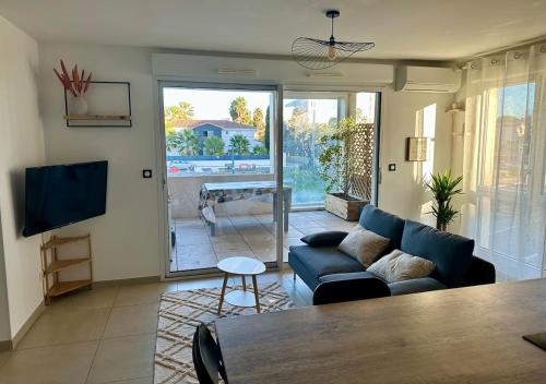 un salon avec un canapé bleu et une télévision dans l'établissement Très bel appartement - 2 chambres, à Montpellier