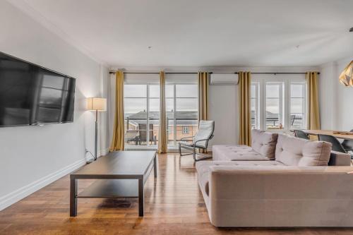 a living room with a couch and a table at INITIAL - ESPACE SOLEIL - Chutes-Montmorency + VUE in Boischâtel