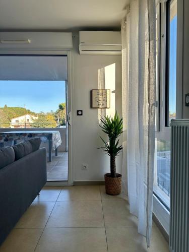 un salon avec un canapé et une plante dans l'établissement Très bel appartement - 2 chambres, à Montpellier