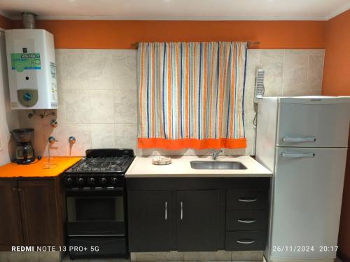 ビージャ・ヒアルディノにあるCasa de huéspedes con pileta.のキッチン(コンロ、シンク、冷蔵庫付)