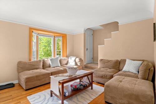 a living room with two couches and a table at Modern Townhouse Near Everything Shopping Center in Dearborn