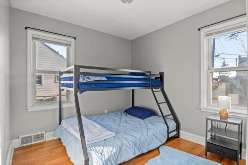 a bedroom with a bunk bed and two windows at 3 Bedroom Fenced Backyard Pets Welcome Sleeps 6 in Lincoln Park