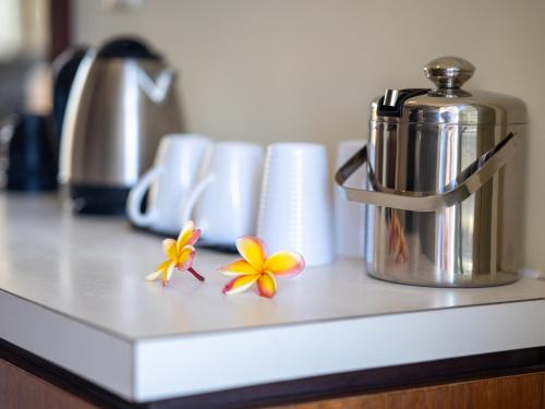 a counter with a coffee pot and flowers on it at Royal Tahitien in Papeete