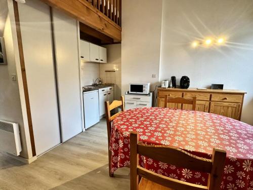 une cuisine avec une table et une cuisine avec une table et des chaises dans l'établissement Résidence Face Sud - maeva Home - Studio 5 personnes - Confort MAE-1881, à La Mongie