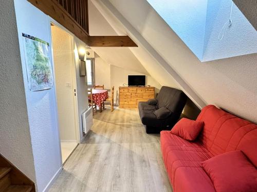 - un salon avec un canapé rouge et une chaise dans l'établissement Résidence Face Sud - maeva Home - Studio 5 personnes - Confort MAE-1881, à La Mongie