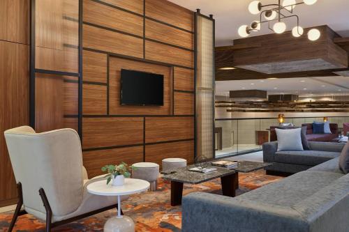 a living room with a couch and a tv at Delta Hotels by Marriott Denver Thornton in Westminster
