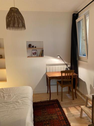 - une chambre avec un bureau, un lit et une table dans l'établissement Appartement de charme au coeur du centre historique, à Bordeaux