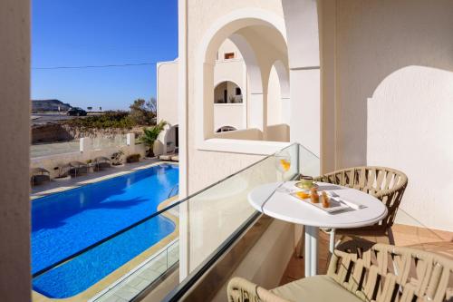 balkon ze stołem i basenem w obiekcie Astir Thira Hotel w Firze