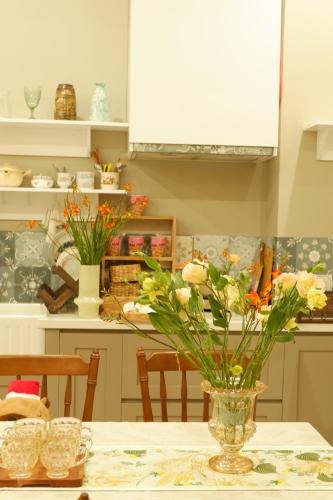 a vase of flowers on a table in a kitchen at Camellia Full House in Da Nang