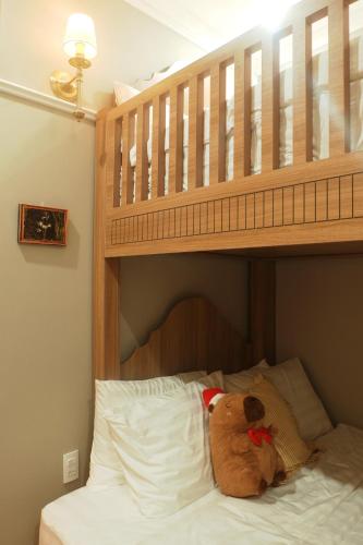 a teddy bear sitting on a bed under a bunk bed at Camellia Full House in Da Nang