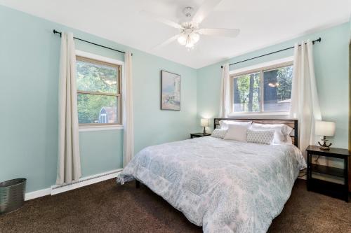 a bedroom with a bed and two windows at Private pool, close to Lake Michigan Beaches in Muskegon