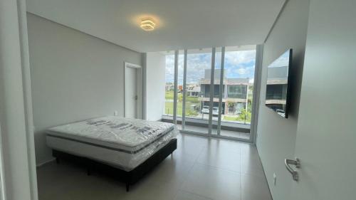 a bedroom with a bed and a large window at Casa Condomínio Ilhas Park Torres in Torres