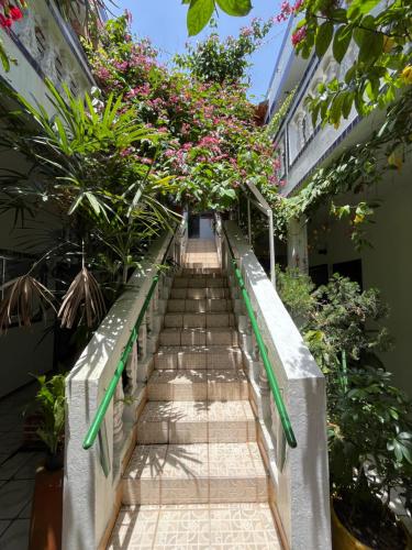a stairway in a building with flowers and plants at Pousada Weiss Blau in Ilha Comprida