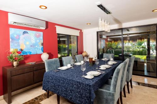 a dining room with a long table and chairs at Sunset Paradise Villa at Nichupté Lagoon in Cancún