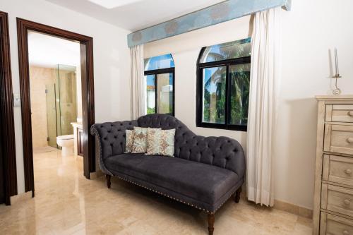 a black couch in a living room with a window at Sunset Paradise Villa at Nichupté Lagoon in Cancún