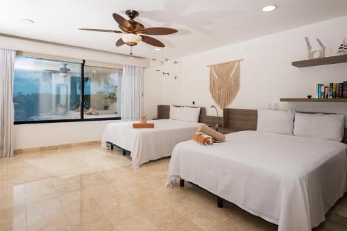 a bedroom with two beds and a ceiling fan at Sunset Paradise Villa at Nichupté Lagoon in Cancún