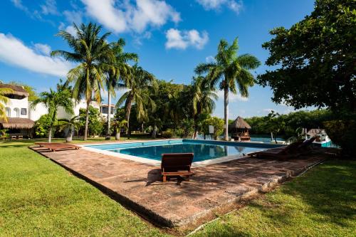 a swimming pool with a chair in a yard at Sunset Paradise Villa at Nichupté Lagoon in Cancún