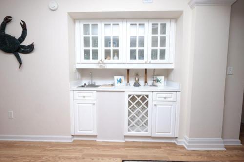 a white kitchen with a sink and a window at Whitney Parish Retreat Beachfront Bliss in Pawleys Island