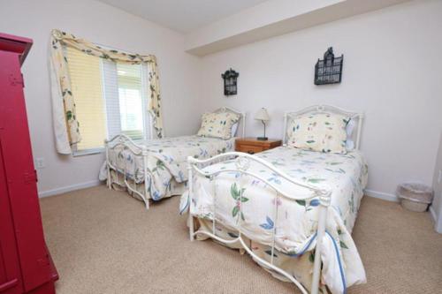 a bedroom with two beds and a window at Whitney Parish Retreat Beachfront Bliss in Pawleys Island