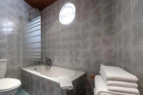 une salle de bain avec une baignoire, des toilettes et un lavabo dans l'établissement Casa do Farol - Charming Townhouse, à Lagos