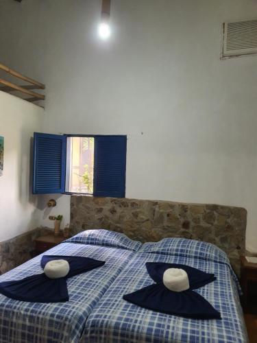 a bedroom with a bed with black pillows and a blue and white at Hostal Nova Colonial in Puerto Colombia