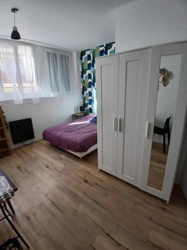 - une chambre avec un lit et une porte coulissante dans l'établissement Comfortable studio pour 2 personnes, à Dijon