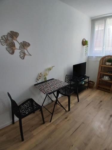 - un salon avec une table et des chaises dans l'établissement Comfortable studio pour 2 personnes, à Dijon