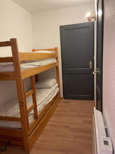 a room with two bunk beds and a door at Jolie T2 en plein centre-ville ville de Font-Romeu in Font Romeu Odeillo Via