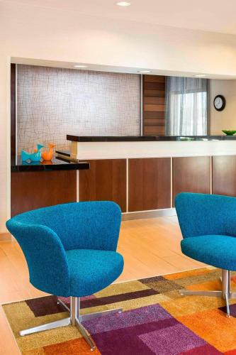 two blue chairs in a room with a table at Fairfield Inn & Suites Mansfield Ontario in Mansfield