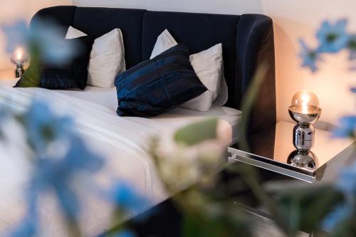 Schlafzimmer mit einem Bett mit einem schwarzen Kopfteil und Kissen in der Unterkunft Swiss Flat Rental in Lausanne