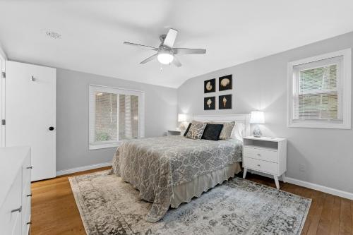 a white bedroom with a bed and a ceiling fan at Hillside Cottage- Great Vacation Rental with Private Pool in Muskegon