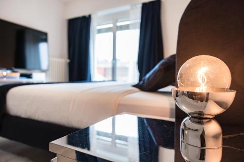 ein Schlafzimmer mit einem Bett und einer Kerze auf einem Tisch in der Unterkunft Swiss Flat Rental in Lausanne