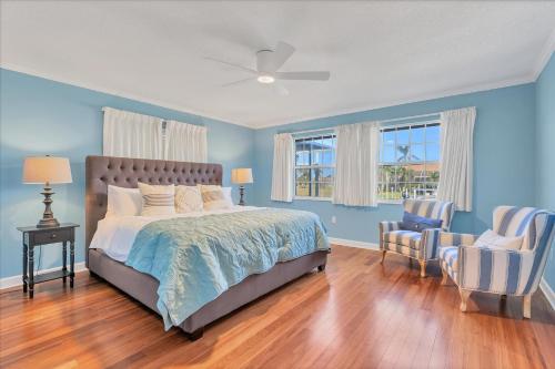 1 dormitorio con paredes azules, 1 cama y 1 silla en 1406 Surfbird, en Punta Gorda