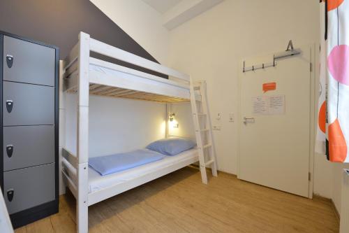 a bedroom with two bunk beds and a ladder at Townside Hostel Bremen in Bremen