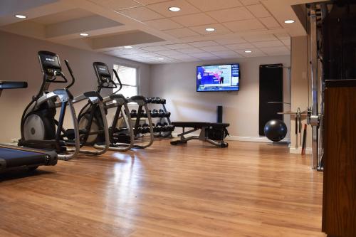 a gym with a row of exercise bikes and a flat screen tv at Delta Hotels by Marriott Indianapolis East in Indianapolis